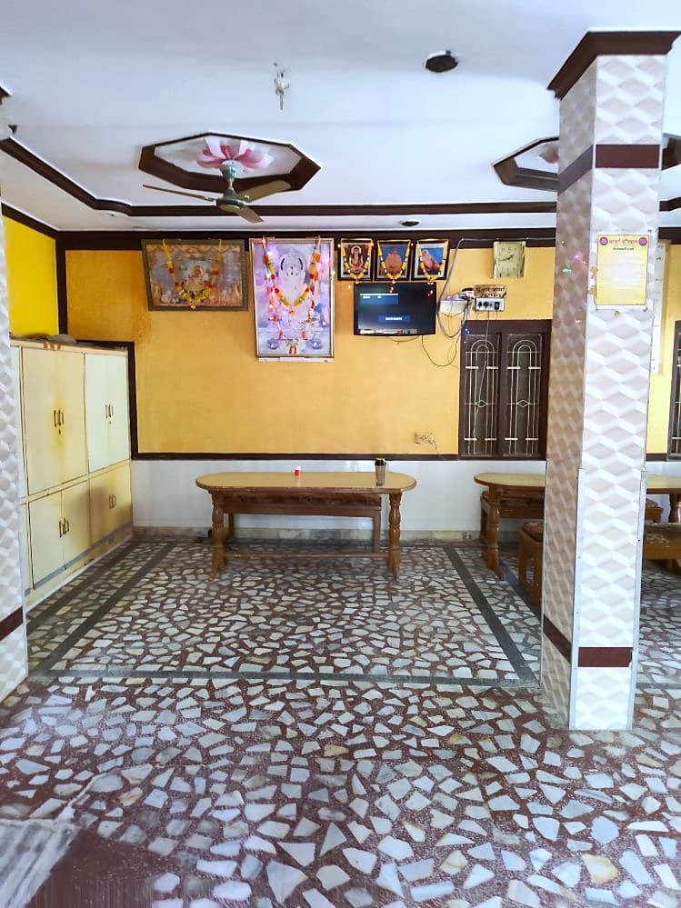 Dining hall of Sharma Girls Hostel with tables and benches